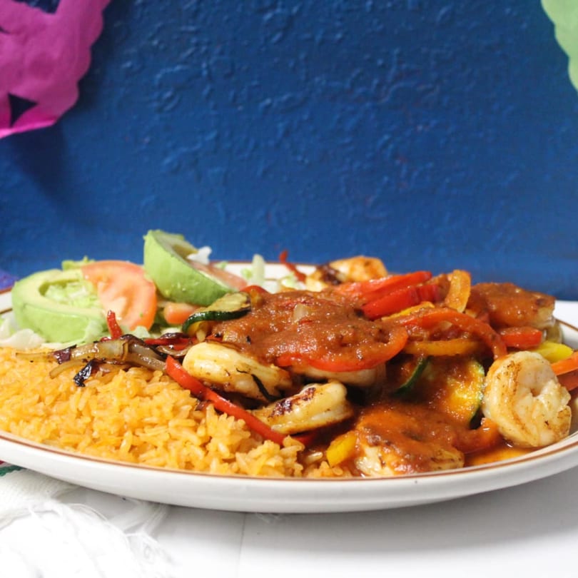 El Sazon Mexican Grill's shrimp fajitas with rice, avocado, and salad on a white plate.